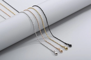 Detailed macro view of four minimalist stainless steel snake chains in various metal finishes