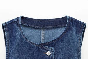 Dettaglio dello scollo del gilet in denim blu con bottone in metallo argento inciso JEANS