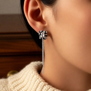 Detail of square vintage earring with long tassel chain and crystal inlay on model