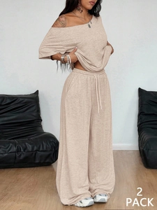 Close-up of beige knitted loungewear set featuring wide-leg pants and 2 pack label