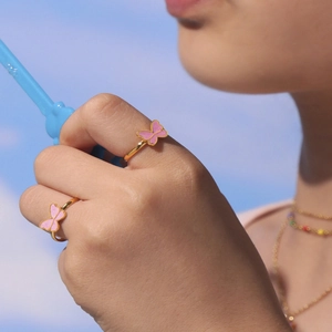 Conjunto de joyas de mariposa rosa para niños con anillos dorados en una modelo