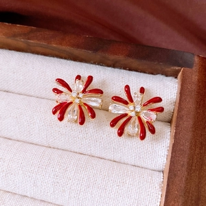 Macro detail of red floral earring with 18k gold plating and sparkling zircon stones