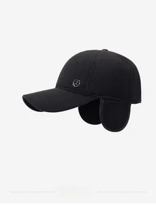 Detail of black wool winter cap with ear flaps and side metal shield logo for men
