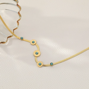 Bohemian gold snake chain necklace featuring sun-patterned turquoise oval pendants