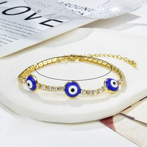 Detailed macro of gold-plated evil eye bracelet with blue enamel and zircon stones
