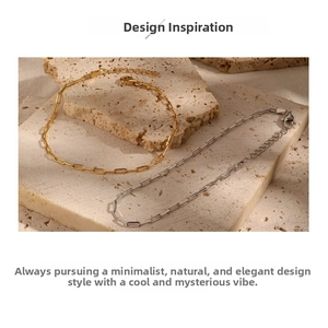 Detail view of gold and silver paperclip bracelets with lobster clasp on stone surface