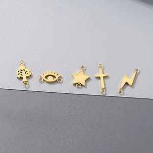 Detailed view of five gold stainless steel charms including star and cross for DIY jewelry