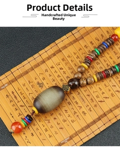 Macro detail of ethnic wooden beaded necklace with agate pendant on bamboo background