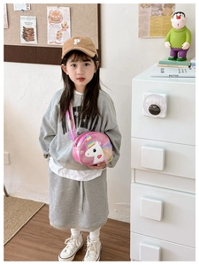 Detail of pink unicorn crossbody bag with 3D cartoon design on a young girl model