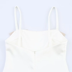 Detail of white satin dress featuring thin shoulder straps and a hidden back zipper closure