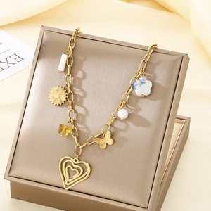 Gold charm necklace with heart and butterfly pendants on a satin background
