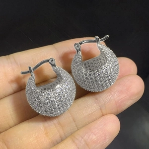 Detailed close-up of sparkling silver hoop earrings with dense pavé-set clear zircons