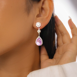 Gros plan d'une boucle d'oreille goutte violette avec motifs floraux sur mannequin