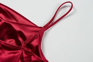 Detail of adjustable silver metal buckles on dark red satin evening dress straps
