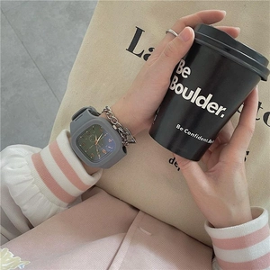 Fashionable grey square digital watch for girls shown with a coffee cup and casual bag