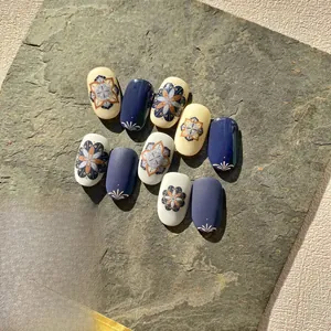 Close-up of retro bohemian mandala nail stickers with navy blue and matte beige patterns