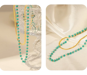 Detail of double-layer gold snake chain and turquoise beaded necklace on silk