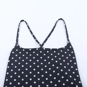 Détail de robe d'été dos nu à pois noirs avec bretelles croisées et tissu brillant