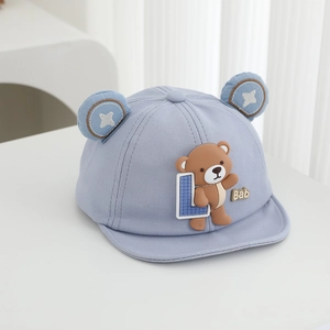 Close-up of light blue baby cap featuring 3D bear doll and cute bear ears detail