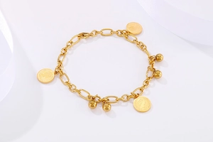 Dettaglio del bracciale a sfere dorate con ciondolo moneta Elizabeth II stile vintage