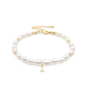 Detailed macro view of baroque freshwater pearls and a gold-plated letter I charm