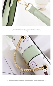 Dettaglio borsa a tracolla verde menta con catena dorata e motivi a tema viaggio