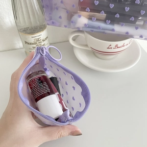 Detail of purple mesh makeup bag with flocked hearts showing capacity for cosmetics