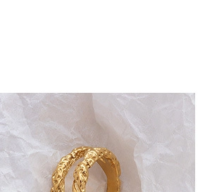 Makroaufnahme von vergoldetem quadratischem Ring mit handgefertigter Hammerschlag-Textur