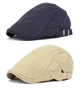 Detailed view of navy and beige cotton flat caps with subtle herringbone texture