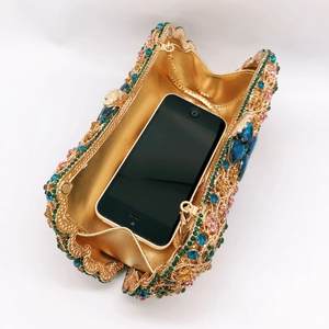Detailed interior of gold hollow evening bag with multi-colored crystals and phone