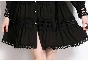 Detail of lace hem and pearl buttons on a black vintage-style standing collar dress