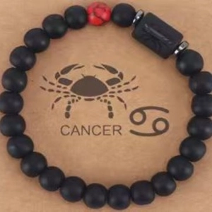 Cancer Sternzeichen Armband mit matten schwarzen Steinen und Tigerauge auf Kraftpapier