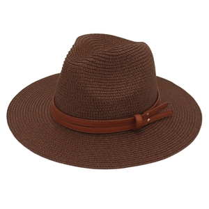 Close-up of woven straw fedora hat with brown faux leather belt and metal rivet details