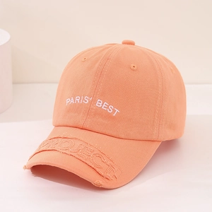 Detail view of the embroidered PARIS BEST text on a vibrant orange kids baseball cap