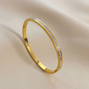 Close-up of gold-plated titanium steel bracelet featuring a row of pavé cubic zirconia