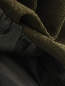 Close-up of olive green knitted fabric texture and premium lining on the vest top