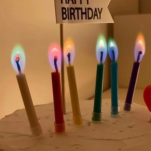 Close-up of five burning birthday candles with vibrant colorful flames on cake