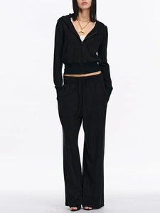 Women's black zip-up hoodie set with thumbhole sleeves and matching drawstring wide-leg pants