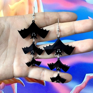 Fashionable black acrylic bat drop earrings for Halloween featuring a triple-tier design