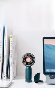 Detail of dark green portable fan showing rose gold accents and foldable desktop stand