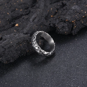Macro shot of silver stainless steel ring with detailed dragon scale texture on black stone
