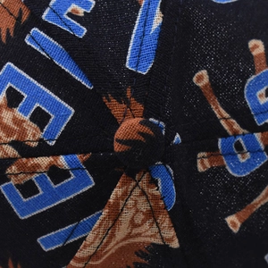 Détail du haut d'une casquette avec couture et imprimé lettres colorées sur coton
