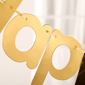 Detail of shiny gold foil Happy Birthday banner cardstock with elegant metallic finish