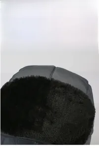 Détail d'un bonnet de ski d'hiver en tissu gris avec une doublure en fausse fourrure noire