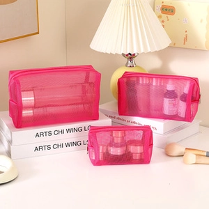 Three sizes of magenta mesh cosmetic bags for travel storage shown in a home setting