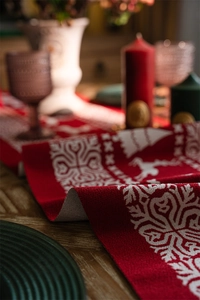 Close-up of red and white jacquard table runner with reindeer and snowflake knit patterns
