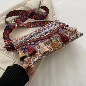 Close-up of ethnic woven crossbody bag with colorful geometric patterns and long tassels