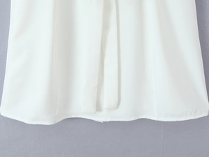 Detailed close-up of white dress fabric with decorative lacing and clean lace edges