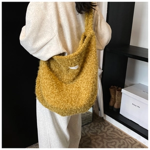 Detailed plush texture of the mustard yellow crossbody hobo bag with a soft woven label