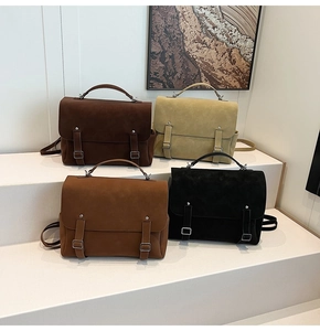 Close-up of four matte vintage backpacks in brown, khaki and black on a display stand